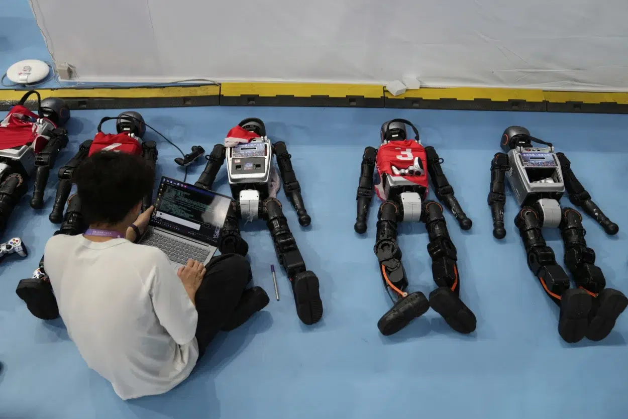 Un technicien travaille sur des robots lors des World Humanoid Robot Games à Pékin, © Associated Press